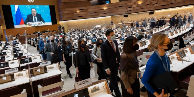 Ambassadors and diplomats leave the room while Russia's foreign minister, Sergei Lavrov (on screen), addresses with a pre-recorded video message at the Conference on Disarmament in Geneva, Switzerland, Tuesday, March 1, 2022.