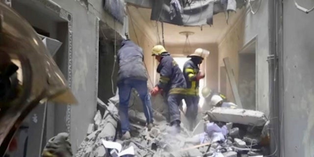 Firemen work inside the regional administration building in the city's central square of Kharkiv, Ukraine, after Russian shelling, Tuesday, March 1, 2022.