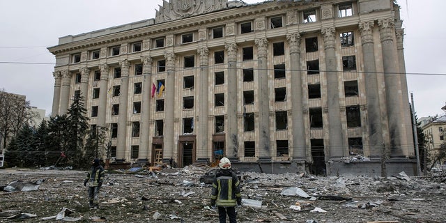 Członek ukraińskich służb ratunkowych patrzy na budynek ratusza na centralnym placu po zamachu bombowym w Charkowie na Ukrainie, wtorek, 1 marca 2022 r.