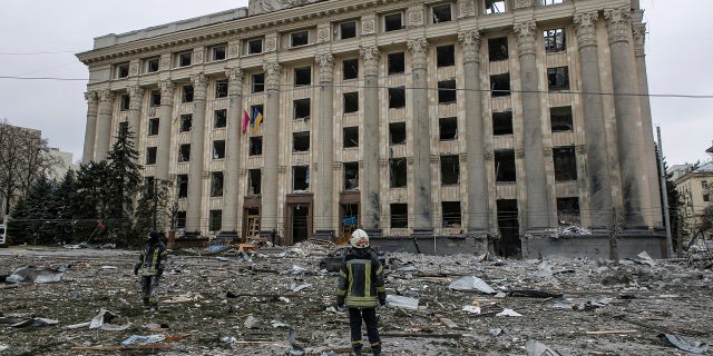 Członek ukraińskich służb ratunkowych patrzy na budynek ratusza na centralnym placu po zamachu bombowym w Charkowie na Ukrainie, wtorek, 1 marca 2022 r.