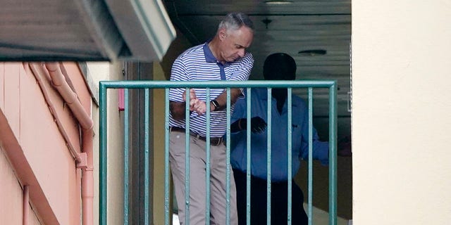 Major League Baseball Commissioner Rob Manfred practices his golf swing as negotiations continue with the players' association toward a labor deal, Tuesday, March 1, 2022, at Roger Dean Stadium in Jupiter, Fla.