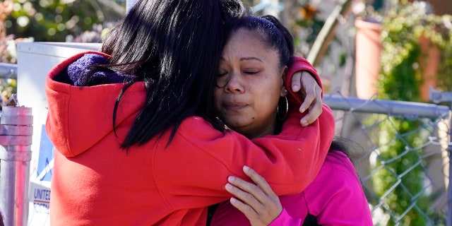 Ana DeJesus, right, is comforted by her daughter, Lizbeth DeJesus after placing a teddy bear and flowers on a memorial at The Church in Sacramento, Calif., on Tuesday, March 1, 2022.