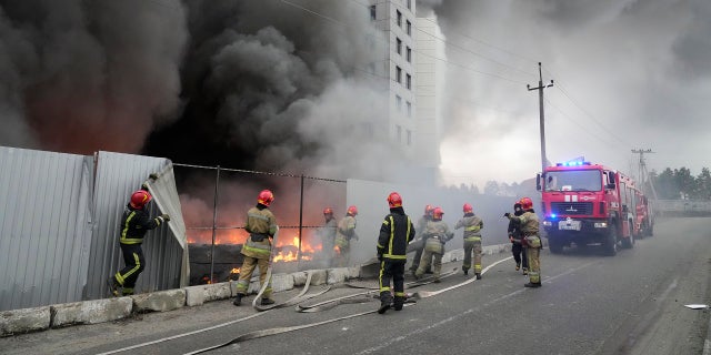 Firefighters work to extinguish a fire at a damaged logistic center after shelling in Kyiv, Ukraine, on Thursday, March 3, 2022. 