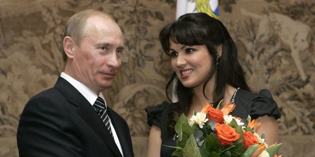 FILE - Russian President Vladimir Putin, left, congratulates Russian opera singer Anna Netrebko after awarding her with the People's Artist of Russia honor, during the 225th anniversary celebrations of the Mariinsky Theater in St. Petersburg, Russia, on Feb. 27, 2008. 