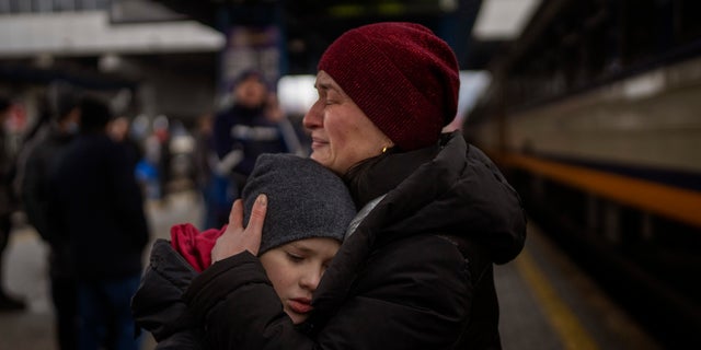 A mother in Ukraine cries with her young son before getting a train to Lviv at the Kyiv station, Ukraine, on March 3, 2022. (AP Photo/Emilio Morenatti)