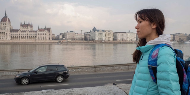 Olena, a Russian citizen fleeing from Kyiv, Ukraine (no family name given for safety reason) looks at the Hungarian Parliament building and the River Danube in downtown Budapest on Friday, March 4, 2022.