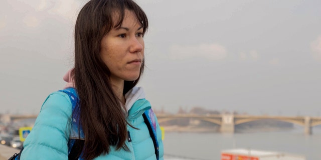 Olena, a Russian citizen fleeing from Kyiv, Ukraine (no family name given for safety reason) stands near the River Danube in downtown Budapest on Friday, March 4, 2022. Olena who years ago left her home country in opposition to Vladimir Putin's government has been forced to flee again — this time from her adopted home of Kyiv — as Putin's armed forces assault Ukraine.