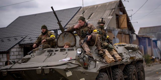 Ukrainian soldiers drive on an armored military vehicle in the outskirts of Kyiv, Ukraine, Saturday, March 5, 2022. (AP Photo/Emilio Morenatti)