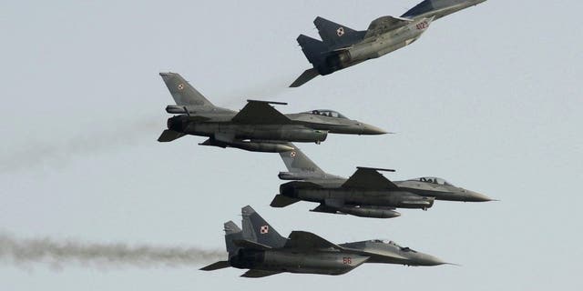   Two Polish Air Force Russians caused Mig 29s to fly over and under two Polish Air Force US manufactured F-16 fighter jets during the air show in Radom, Poland, on August 27, 2011. 
