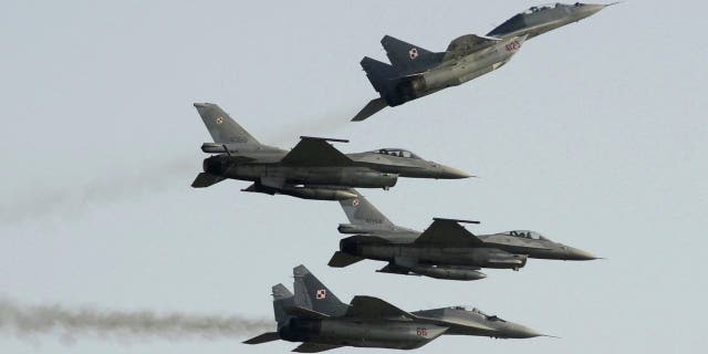 FILE - Two Polish Air Force Russian made Mig 29's fly above and below two Polish Air Force U.S. made F-16's fighter jets during the Air Show in Radom, Poland.