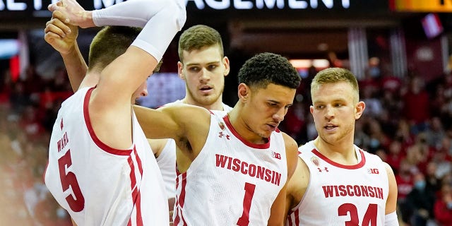 Wisconsin's Johnny Davis (1) is helped by teammates Tyler Wahl (5), Chris Vogt and Brad Davison, 正しい, after Davis was found by Nebraska in the second half of an NCAA college basketball game, 日曜日, 行進 6, 2022, in Madison, Wis. Nebraska's Trey McGowens was charged with a flagrant foul on the play. Nebraska won 74-73.