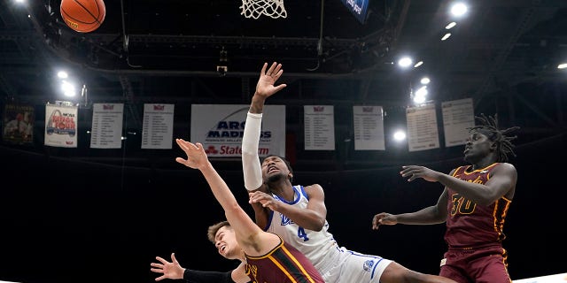 Drake's ShanQuan Hemphill, center, loses control of the ball as Loyola of Chicago's Braden Norris, left, and Aher Uguak (30) defend during the second half of an NCAA college basketball game in the championship of the Missouri Valley Conference tournament Sunday, March 6, 2022, in St. Louis.