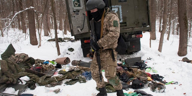 A volunteer of the Ukrainian Territorial Defense Forces inspects a damaged military vehicle in the outskirts Kharkiv, Ukraine's second-largest city, Monday, March 7, 2022.