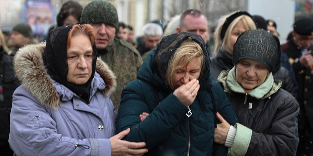 Relatives of Col. Vladimir Zhoga, commander of a reconnaissance battalion of the self-proclaimed Donetsk People Republic mourn during a farewell ceremony in Donetsk, 乌克兰东部, 星期一, 游行 7, 2022. Zhoga has been awarded the Hero of the Russian Federation title posthumously. 