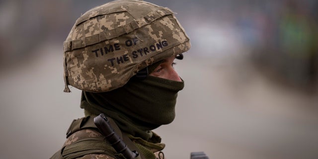 A Ukrainian soldier stands guard at a checkpoint on the outskirts of Kyiv, Ukraine.