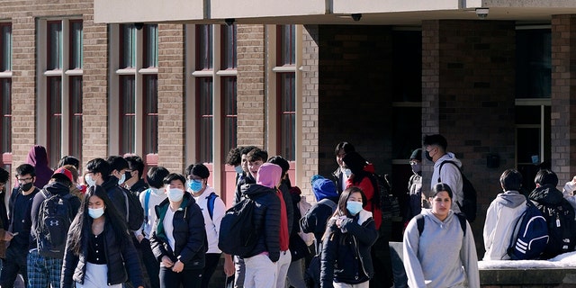 Students, most wearing protective face masks over concerns for coronavirus, walk from North Quincy High School at the end of the school day in Quincy, Mass., Monday, Feb. 28, 2022. (AP Photo/Charles Krupa, File)