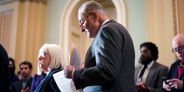 Senate Majority Leader Chuck Schumer, D-N.Y., looks over his notes before taking questions from reporters and speaking about the Russian invasion of Ukraine, at the Capitol in Washington, Tuesday, March 8, 2022.