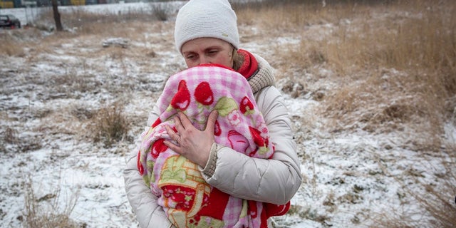 Aksana Opalenko, lat 42, trzyma 2-miesięcznego Mirona, który próbuje go ogrzać po ucieczce z Ukrainy, na przejściu granicznym w Medica, w środę, 9 marca 2022 r. Przedstawiciele ONZ powiedzieli, że rosyjski atak zmusił 2 miliony ludzi.  Ludzie uciekają z Ukrainy.  Inni zostali uwięzieni w oblężonych miastach, cierpiąc na niedobory żywności, wody i lekarstw podczas największej w Europie wojny lądowej od II wojny światowej. 