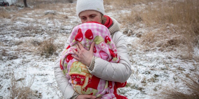 Axana Opalenko, 42, holds Meron, 2 months old, in an effort to warm him after fleeing from Ukraine, at the border crossing in Medyka, Poland, Wednesday, March 9, 2022. U.N. officials said that the Russian onslaught has forced 2 million people to flee Ukraine. It has trapped others inside besieged cities that are running low on food, water and medicine amid the biggest ground war in Europe since World War II. 