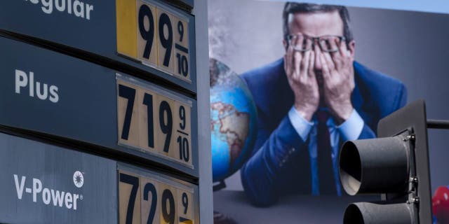 FILE - Gas prices are seen in front of a billboard advertising HBO's Last Week Tonight in Los Angeles, March 7, 2022. 