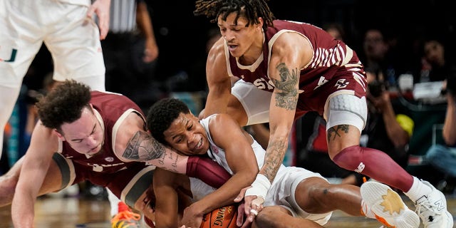Miami's Charlie Moore, sentrum, Boston College's Jaeden Zackery, links, and Makai Ashton-Langford, reg, battle for the ball in the first half of an NCAA college basketball game during quarterfinals of the Atlantic Coast Conference tournament, Donderdag, Maart 10, 2022, In New York.