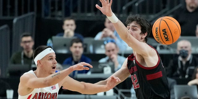 Arizona's Kerr Kriisa (25) passes around Stanford's Maxime Raynaud (42) during the first half of an NCAA college basketball game in the quarterfinal round of the Pac-12 tournament Thursday, March 10, 2022, in Las Vegas.