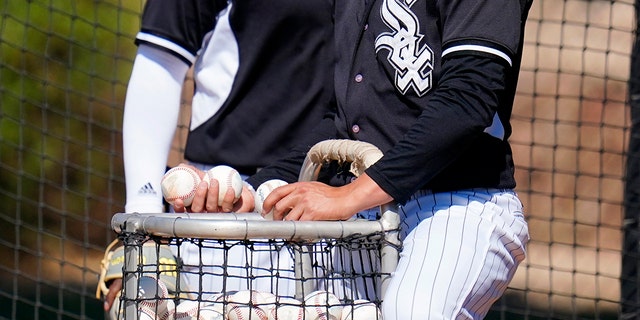 Chicago White Sox minor league players put baseballs back in the basket during batting practice at a minor league spring training workout Thursday, Maart 10, 2022, in Phoenix. Major League Baseball’s acrimonious lockout ended Thursday when a divided players’ association voted to accept management’s offer to salvage a 162-game season that will start April 7. 