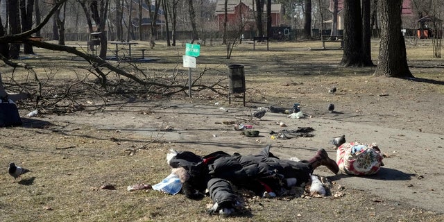 EDS NOTE: GRAPHIC CONTENT - A dead body of a woman resident lies in the center park of the town of Irpin, some 25 km (16 miles) northwest of Kyiv, Friday, March 11, 2022. Kyiv northwest suburbs such as Irpin and Bucha have been enduring Russian shellfire and bombardments for over a week prompting residents to leave their home.