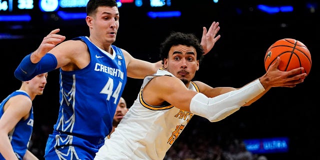 Providence's Justin Minaya, 对, protects the ball from Creighton's Ryan Hawkins (44) during the first half of an NCAA college basketball game in the semifinals of the Big East men's tournament Friday, 游行 11, 2022, 在纽约.