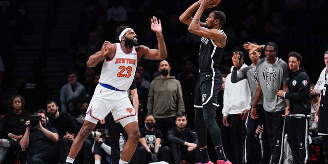 The Brooklyn Nets' Kevin Durant, right, shoots over the New York Knicks' Mitchell Robinson during a game at the Barclays Center Mar. 13, 2022, in New York.