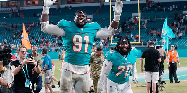 FILE - Miami Dolphins defensive end Emmanuel Ogbah (91) and nose tackle Adam Butler (70) celebrate at the end of an NFL football game against the Baltimore Ravens, giovedi, Nov. 11, 2021, a Miami Gardens, Fla. The Miami Dolphins agreed with Emmanuel Ogbah on a four-year contract and Chase Edmonds on a two-year deal on Monday, marzo 14, 2022.