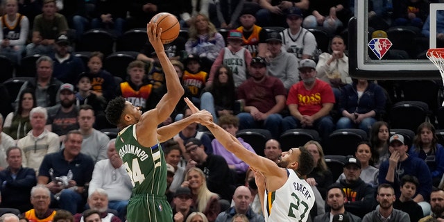 El alero de los Milwaukee Bucks, Giannis Antetokounmpo (34), dispara mientras el centro de Utah Jazz, Rudy Gobert (27), defiende durante la primera mitad de un juego el 14 de marzo de 2022 en Salt Lake City. 