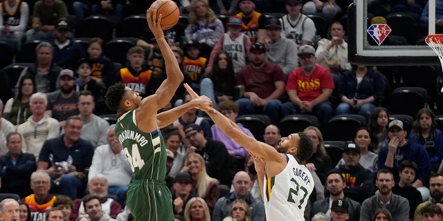 El alero de los Milwaukee Bucks, Giannis Antetokounmpo (34), dispara mientras el centro de Utah Jazz, Rudy Gobert (27), defiende durante la primera mitad de un juego el 14 de marzo de 2022 en Salt Lake City. 