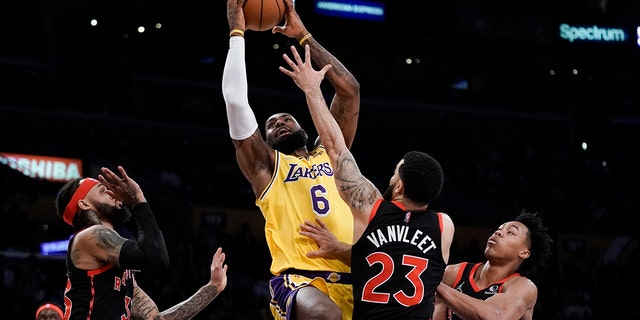Los Angeles Lakers' LeBron James, 센터, 왼쪽, goes up for a basket under pressure by Toronto Raptors' Fred VanVleet (23) during first half of an NBA basketball game Monday, 행진 14, 2022, 로스 앤젤레스. 