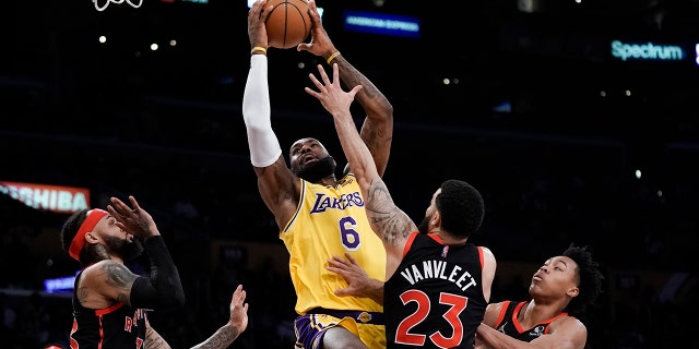 Los Angeles Lakers' LeBron James, 센터, 왼쪽, goes up for a basket under pressure by Toronto Raptors' Fred VanVleet (23) during first half of an NBA basketball game Monday, 행진 14, 2022, 로스 앤젤레스.