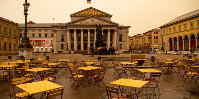 Over the Max-Joseph-Platz and the Staatsoper bad weather with Sahara dust is coming up that colors the sky yellow/orange in Munich, Germany.