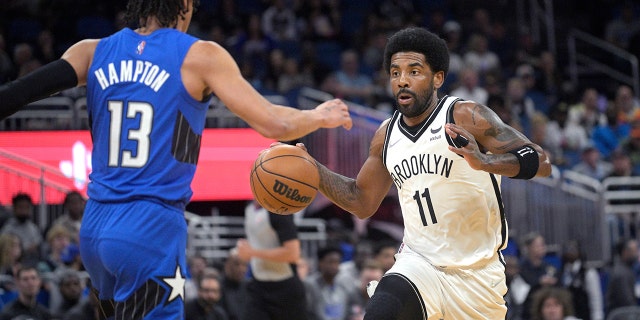 Brooklyn Nets guard Kyrie Irving (11) drives in front of Orlando Magic guard RJ Hampton (13) during the first half of the game on March 15, 2022 in Orlando, Fla. 