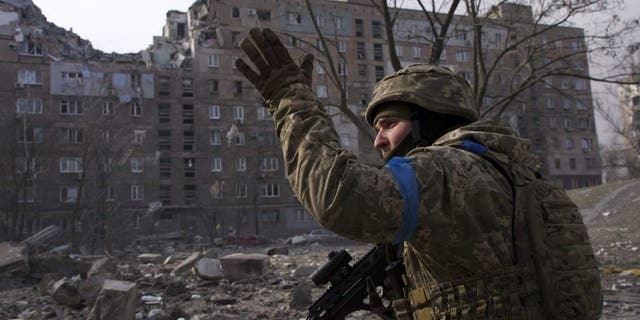 A Ukrainian service member guards his position in Mariupol, Ukraine, Saturday, March 12, 2022. 