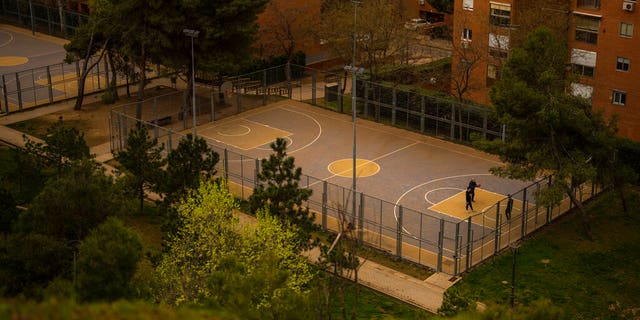 People play basketball in a basketball court covered with dust as storm Celia blew sand from the Sahara desert at the the Cerro del Tio Pio park in Madrid, Spain.
