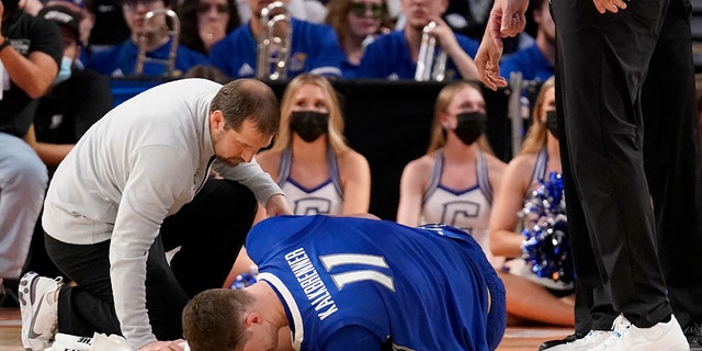 Team staff assist Creighton center Ryan Kalkbrenner (11) who suffered an unknown leg injury in a first-round game against San Diego State in the NCAA college basketball tournament in Fort Worth, 德州, 星期四, 游行 17, 2022. 