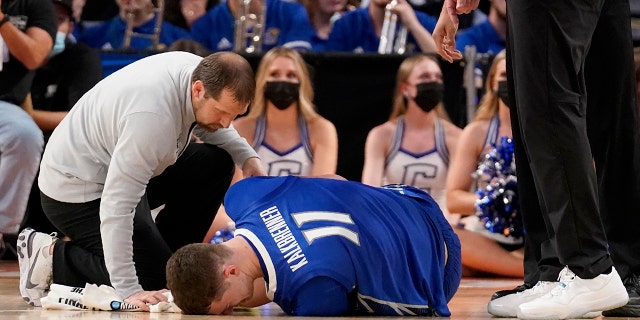 Team staff assist Creighton center Ryan Kalkbrenner (11) who suffered an unknown leg injury in a first-round game against San Diego State in the NCAA college basketball tournament in Fort Worth, 德州, 星期四, 游行 17, 2022.