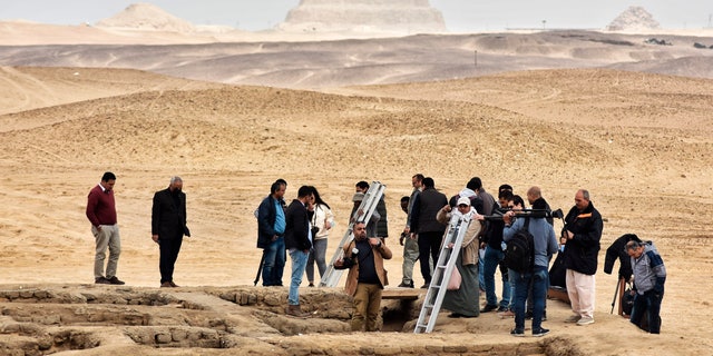 Reporters prepare to enter a recently discovered tomb near the famed Step Pyramid, in Saqqara, south of Cairo, Egypt, Saturday, March 19, 2022. 
