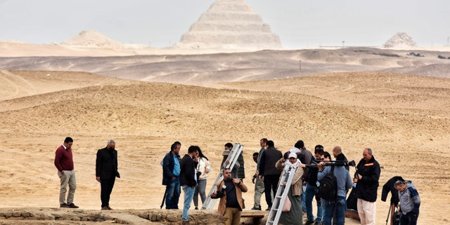 Reporters prepare to enter a recently discovered tomb near the famous Step Pyramid, in Saqqara, south of Cairo, Egypt, Saturday, March 19, 2022.