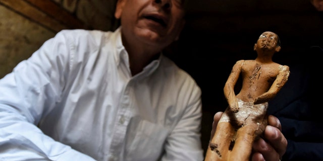 Mostafa Waziri, Secretary General of the Supreme Council of Antiquities, displays a statue found in a recently discovered tomb near the famous Step Pyramid, in Saqqara, south of Cairo, Egypt, Saturday, March 19, 2022.