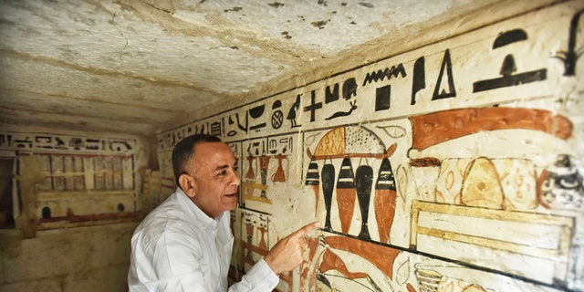 Mostafa Waziri, Secretary General of the Supreme Council of Antiquities, views hieroglyphics inside a recently discovered tomb near the famous Step Pyramid, in Saqqara, south of Cairo, Egypt, Saturday, March 19, 2022.