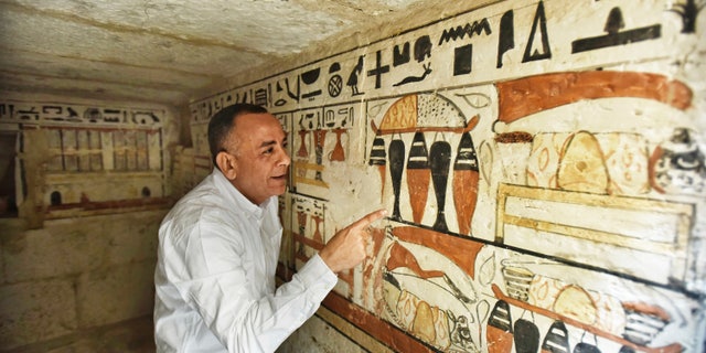 Mostafa Waziri, Secretary General of the Supreme Council of Antiquities, views hieroglyphics inside a recently discovered tomb near the famous Step Pyramid, in Saqqara, south of Cairo, Egypt, Saturday, March 19, 2022.