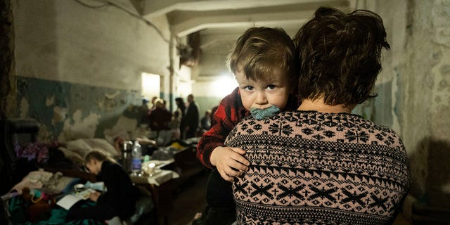 A woman holds a child in an improvised bomb shelter in Mariupol, Ukraine, Monday, March 7, 2022. 