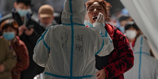 A woman gets a coronavirus test at an outdoor testing site Monday, Maart 21, 2022, Winterspele, Sjina.