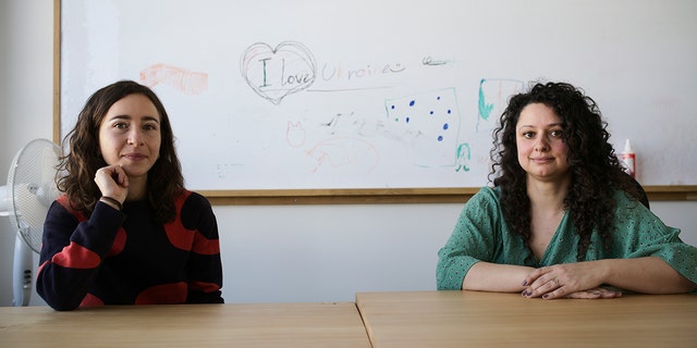 Volunteers Burcak Sevilgen, right, and Faina Karlitski pose for a photo at a space where they organized two school classes for Ukrainian refugees in Berlin, Germany, Monday, March 21, 2022.