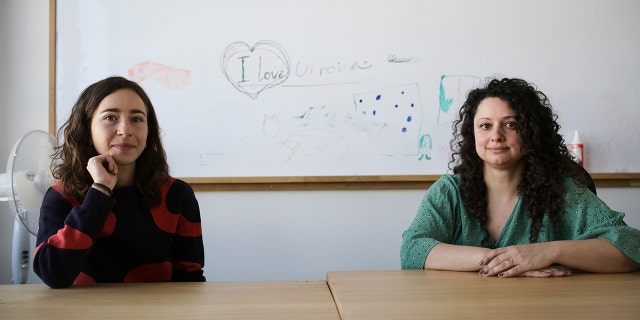 Volunteers Burcak Sevilgen, right, and Faina Karlitski pose for a photo at a space where they organized two school classes for Ukrainian refugees in Berlin, Germany, Monday, March 21, 2022.